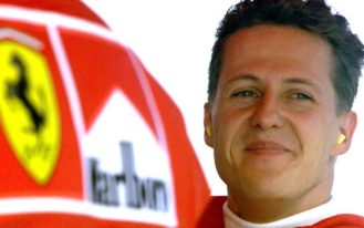 Germany's Michael Schumacher smiles in the pit area after completing his second qualifying session of the Hungarian Formula One Grand Prix in this August 15, 1998 file photo. Ferrari fans held a vigil for Michael Schumacher on his 45th birthday on January 3, 2014, gathering outside the French hospital where the seven times world champion continued to fight for his life after a skiing accident. Schumacher's family thanked the fans in a statement on Friday evening saying they were moved to tears while French media reported that investigators were studying a camera the German had on him at the time of the accident.  REUTERS/Radu Sigheti/Files (HUNGARY - Tags: SPORT MOTORSPORT F1)